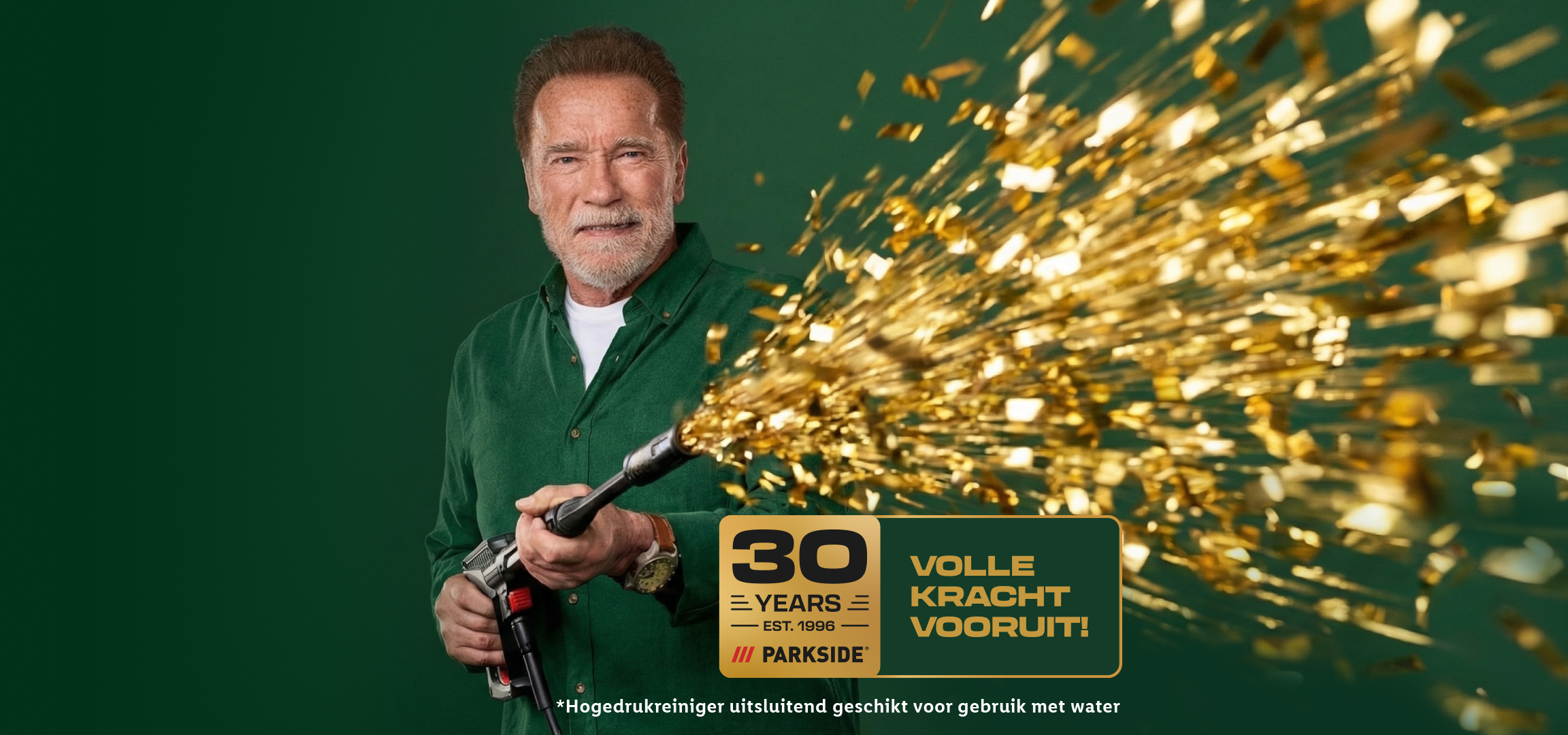 Arnold Schwarzenegger met een hogedrukreiniger die gouden confetti spuit, met de tekst '30 jaar volle kracht vooruit!'