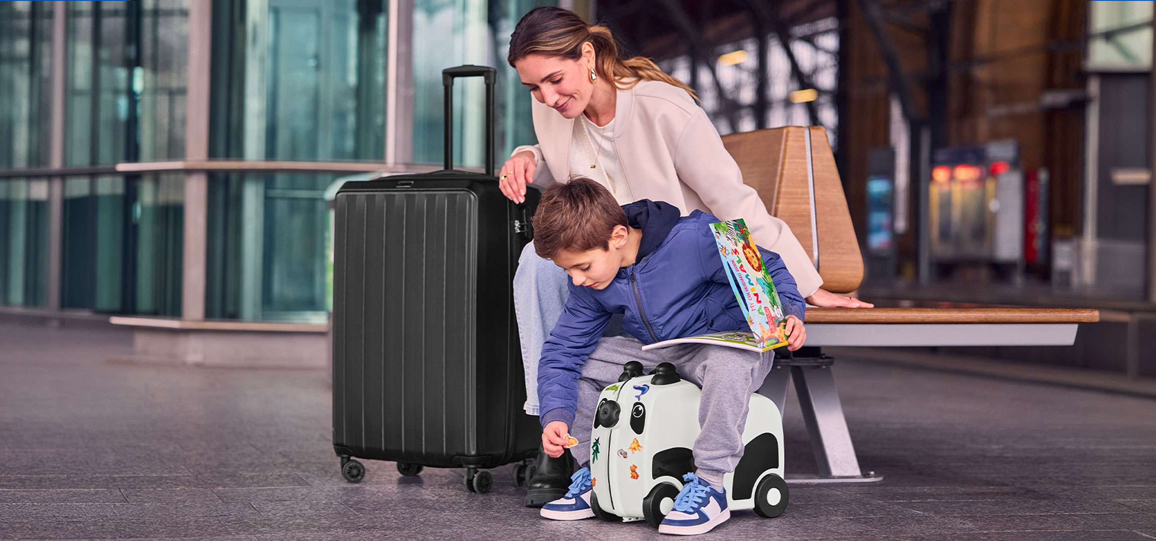 Moeder en kind met bagage op de luchthaven, kind speelt met een rijdende koffer.