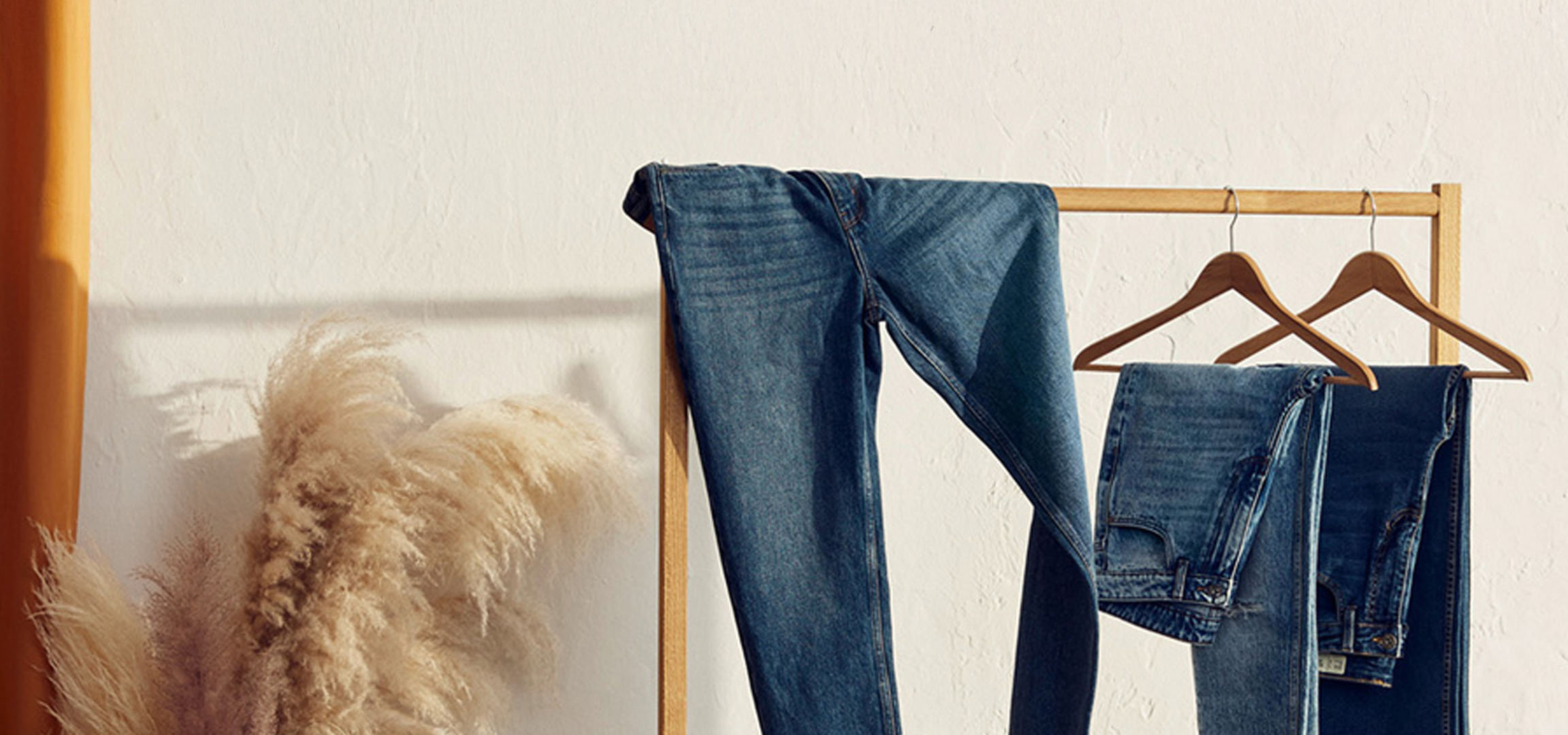 Jeans op een houten hanger.
