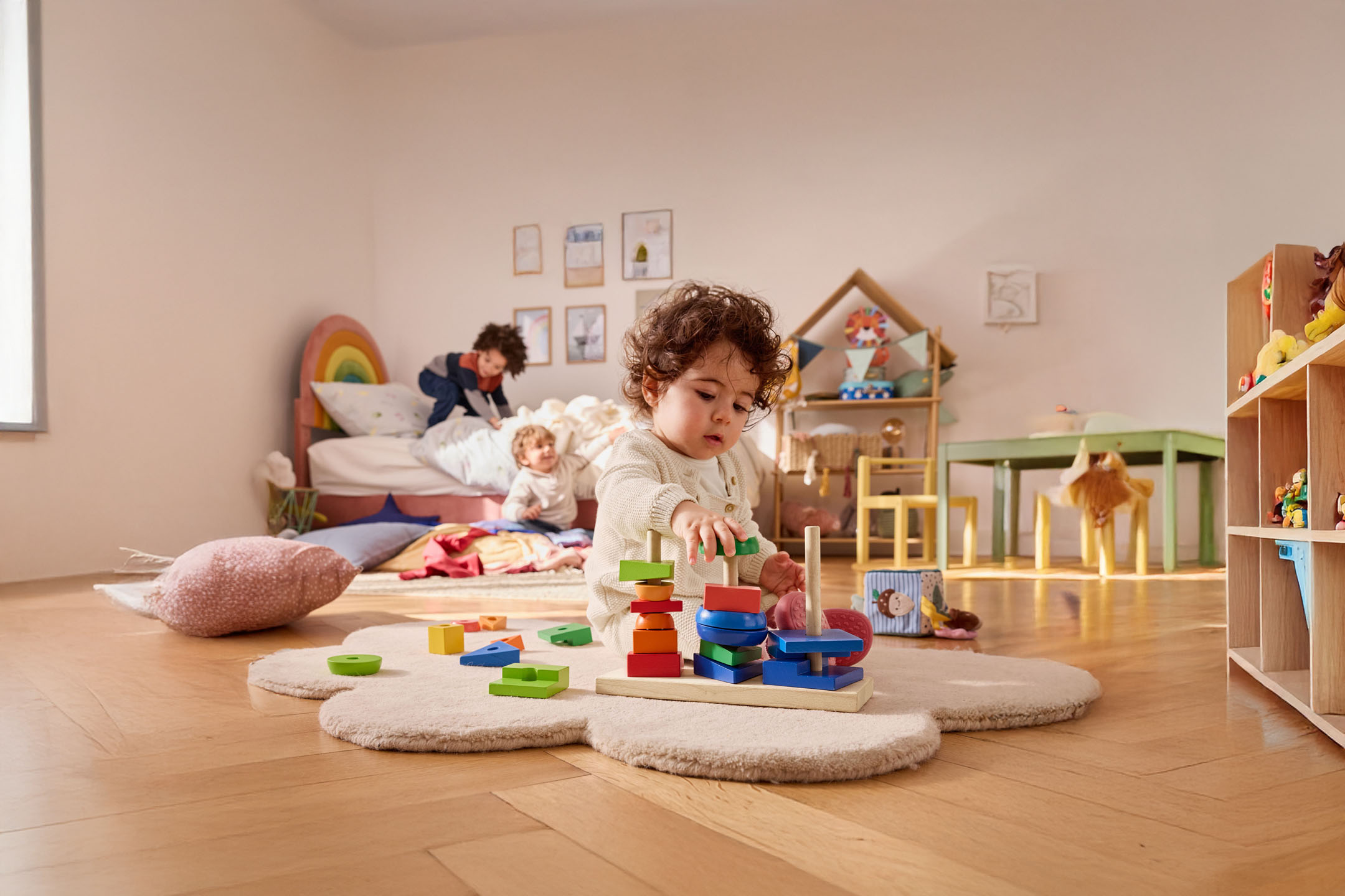 Een klein kind speelt met een houten bouwspel in zijn kamer.