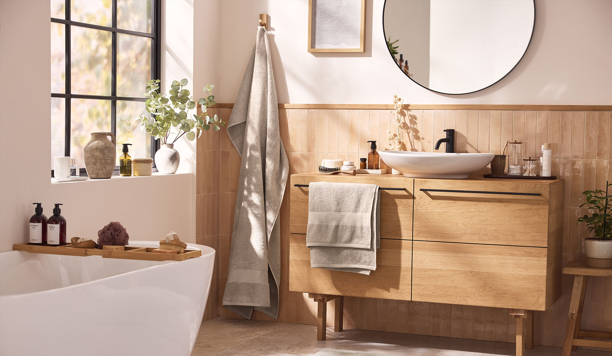 Moderne badkamer met houten badkamermeubels, een badkuip en een raam.