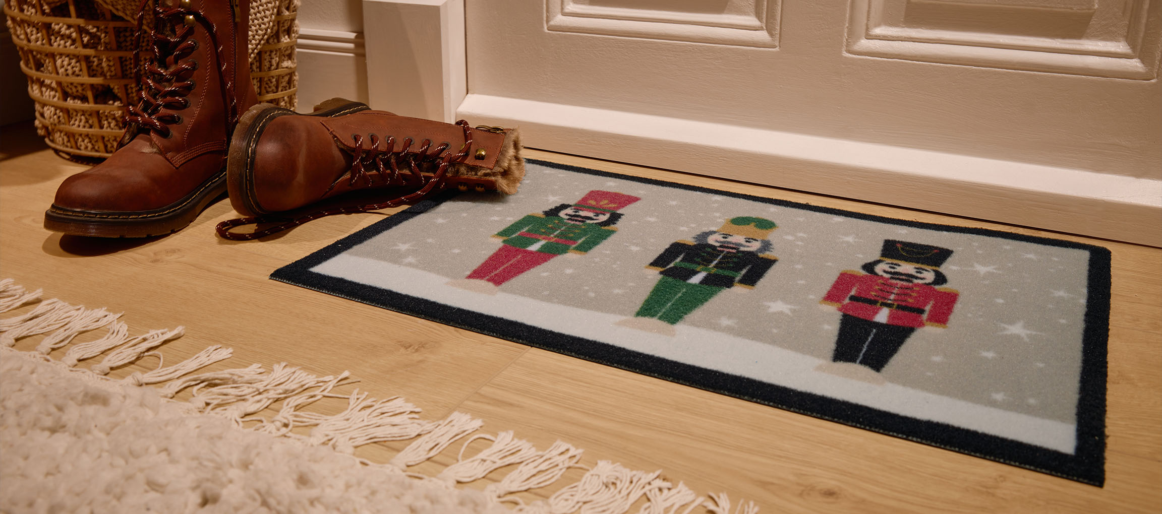 Kerst notenkraker deurmat, bruine laarzen en rieten mand bij de ingang.