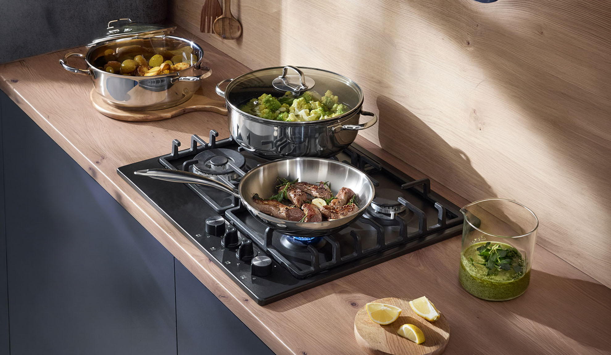 Gasfornuis met pan en potten op een houten aanrecht, maaltijd wordt bereid.
