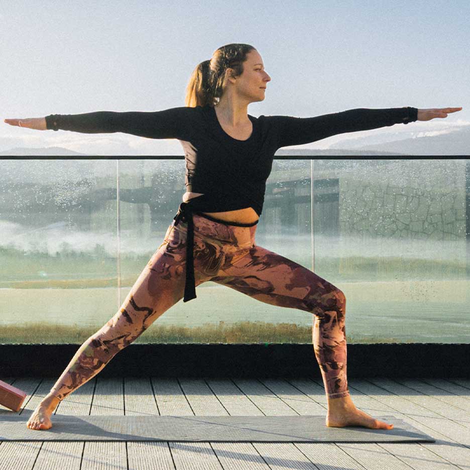Vrouw in legging en yogatop op een terras