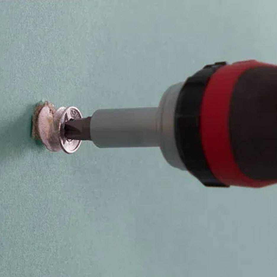 Elektrische schroevendraaier met boorbit die een schroef in de muur draait.