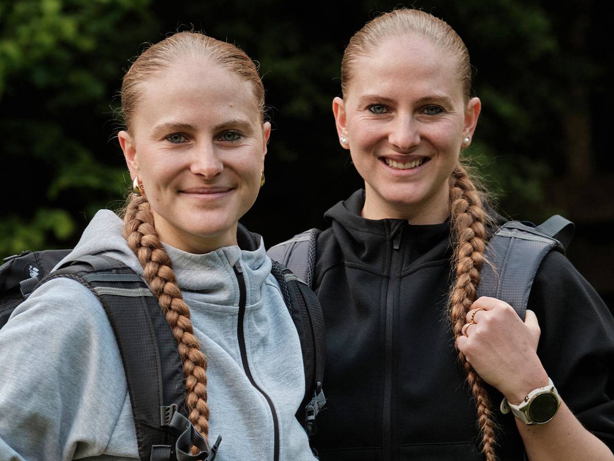 Twee vrouwen met rugzakken staan samen.